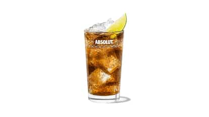 Malibu and Cola in an Absolut highball glass with ice and a lime wedge on white background