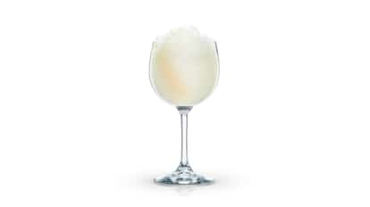 Mango Delight served in a stemmed wine glass with crushed ice on white background