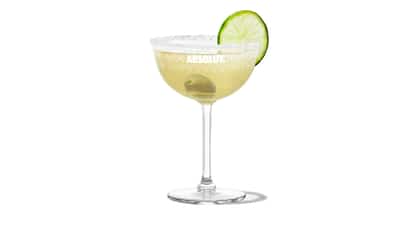 Mexican Martini in an Absolut coupe with a salt rim, olive and lime wheel on white background