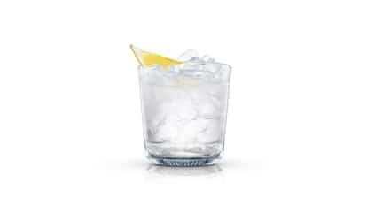 Pure Yoga in an Absolut rocks glass with crushed ice and a lemon wedge on white background