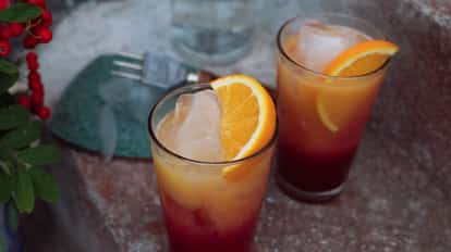 Two So Sunrise served in tall glasses with ice and orange wedges.