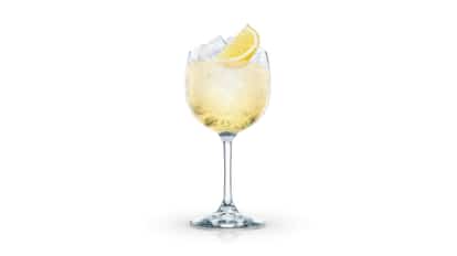 Spritzer in a stemmed wine glass with ice and a lemon wedge on white background