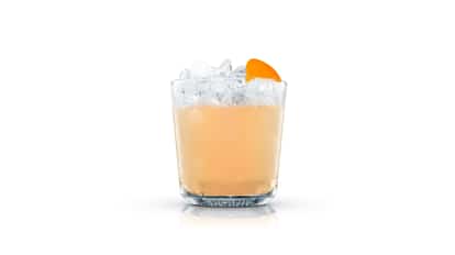 Tequila Guyaba in an Absolut rocks glass with crushed ice and an orange wedge on white background