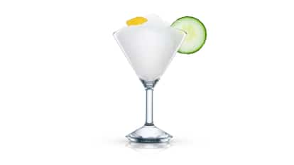 Two Inches of Cucumber in a martini glass with crushed ice, cucumber slice and lemon peel on white background