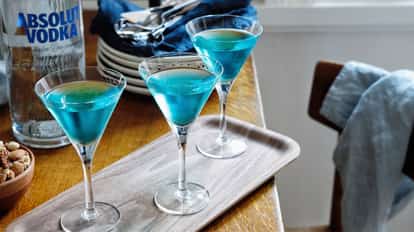 Volga, Volga in three martini glasses on a wooden tray with an Absolut Vodka bottle visible