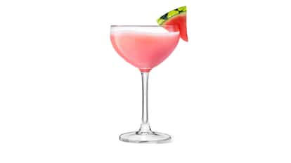 Watermelon Vodka Cocktail in a coupe glass with a watermelon wedge on the rim on white background